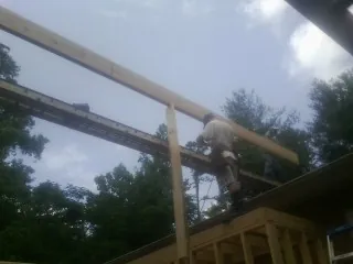 Carpenter setting a ridge beam over a new addition frame — Ice Dam Removal by Roofing Brothers in Ferdinand