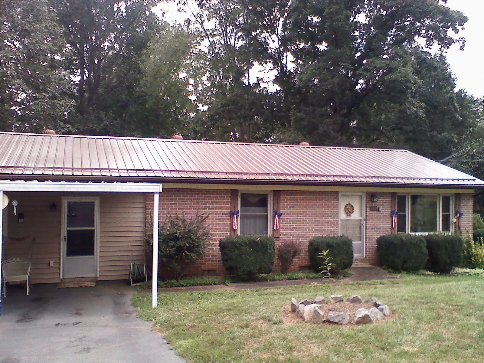 Bronze metal roof and carport on a brick ranch home — Roof Repair work by our crew in Ferdinand